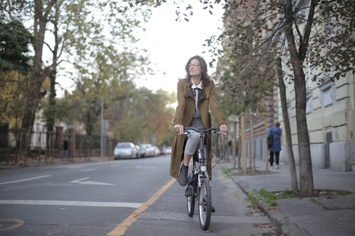 自転車に乗る茶色のコートの女性