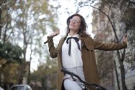 Woman in Brown Blazer Riding a Bicycle