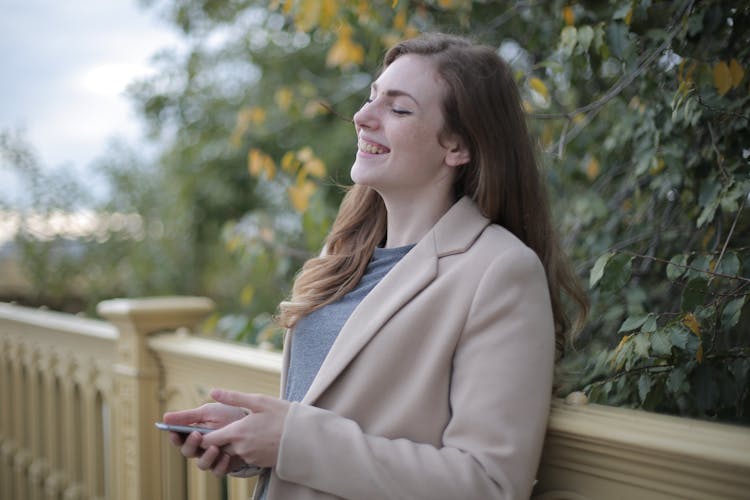 A Jolly Woman Holding Smartphone 