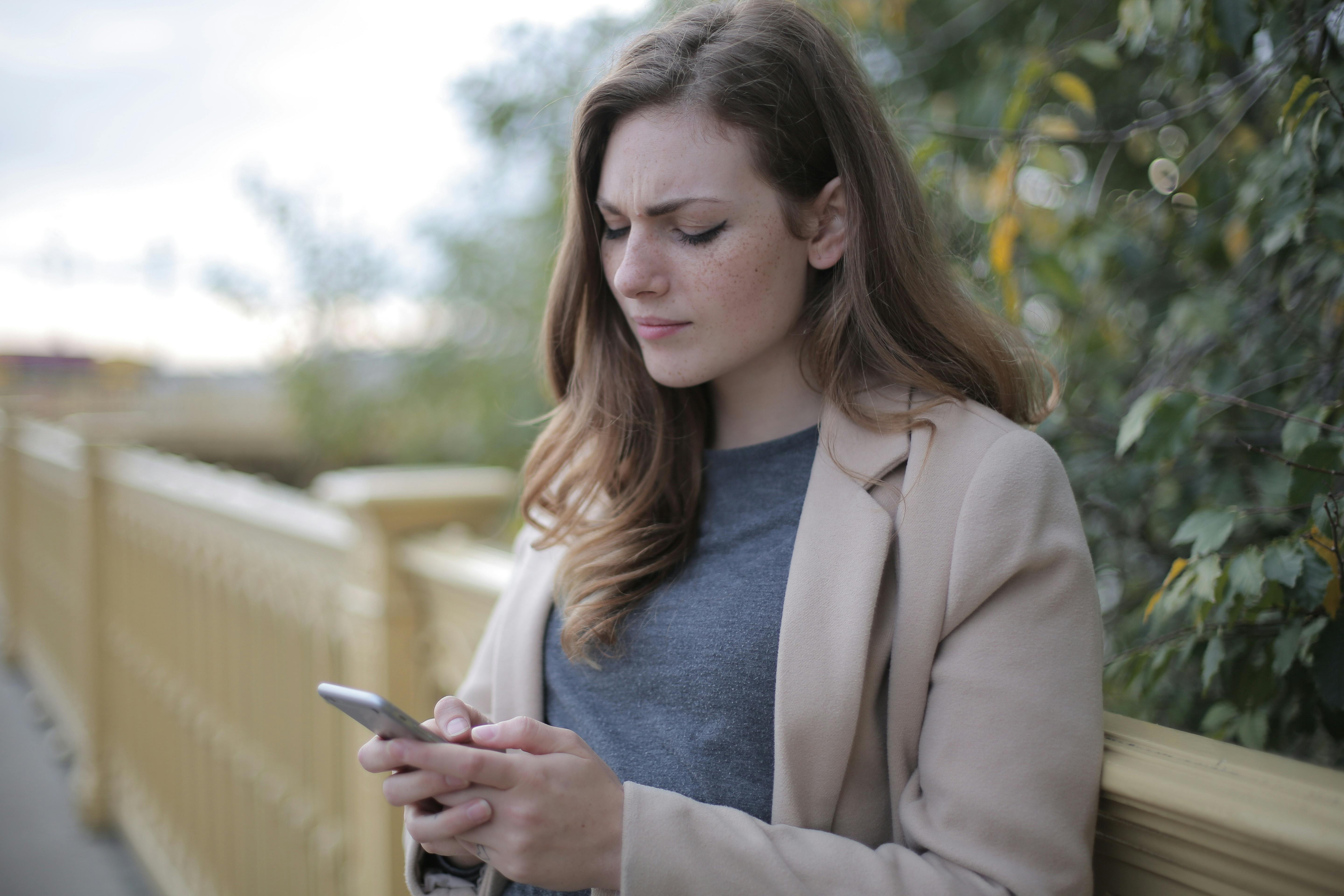 pensive woman in using smartphone