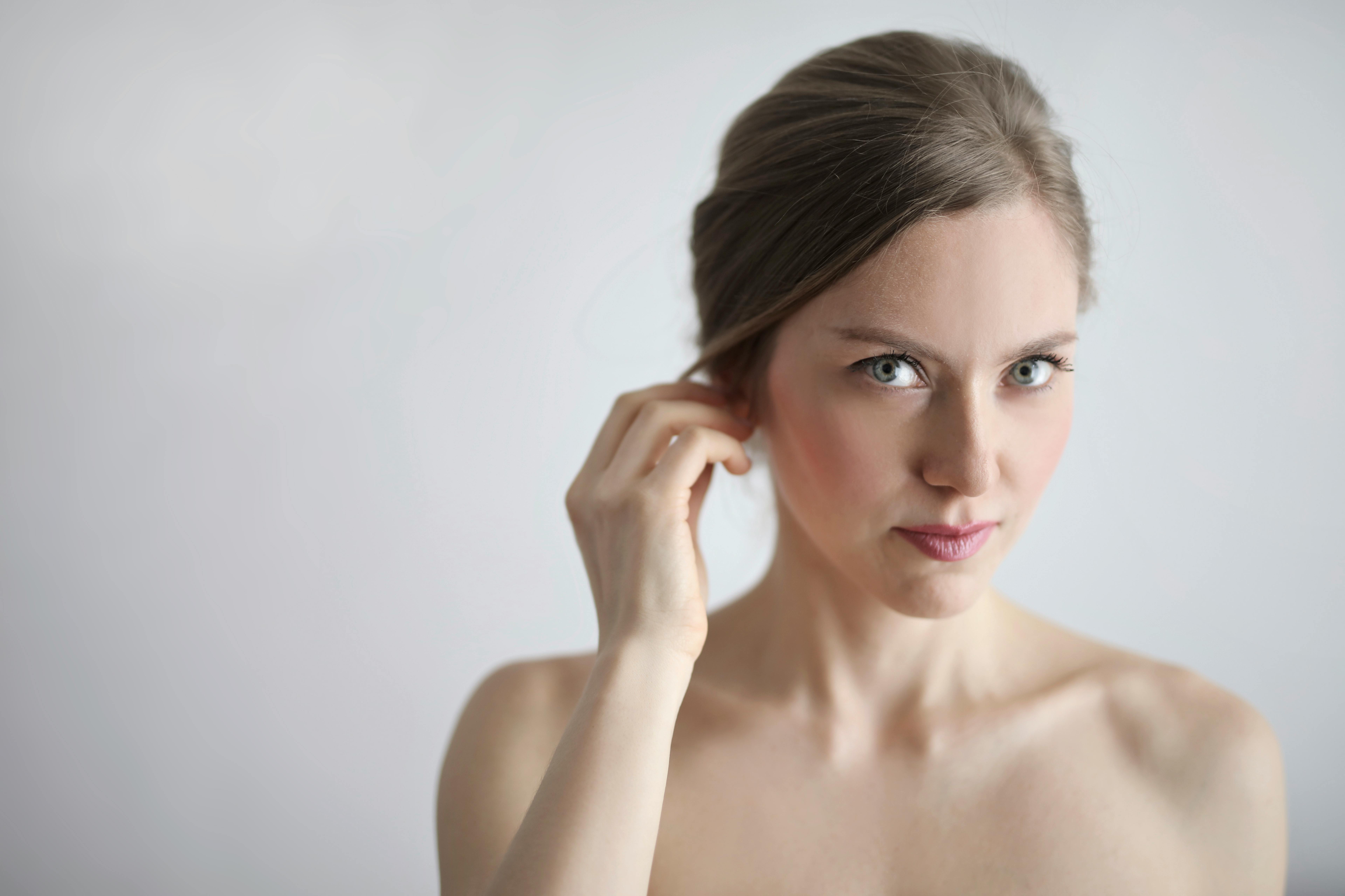 topless woman holding her ears