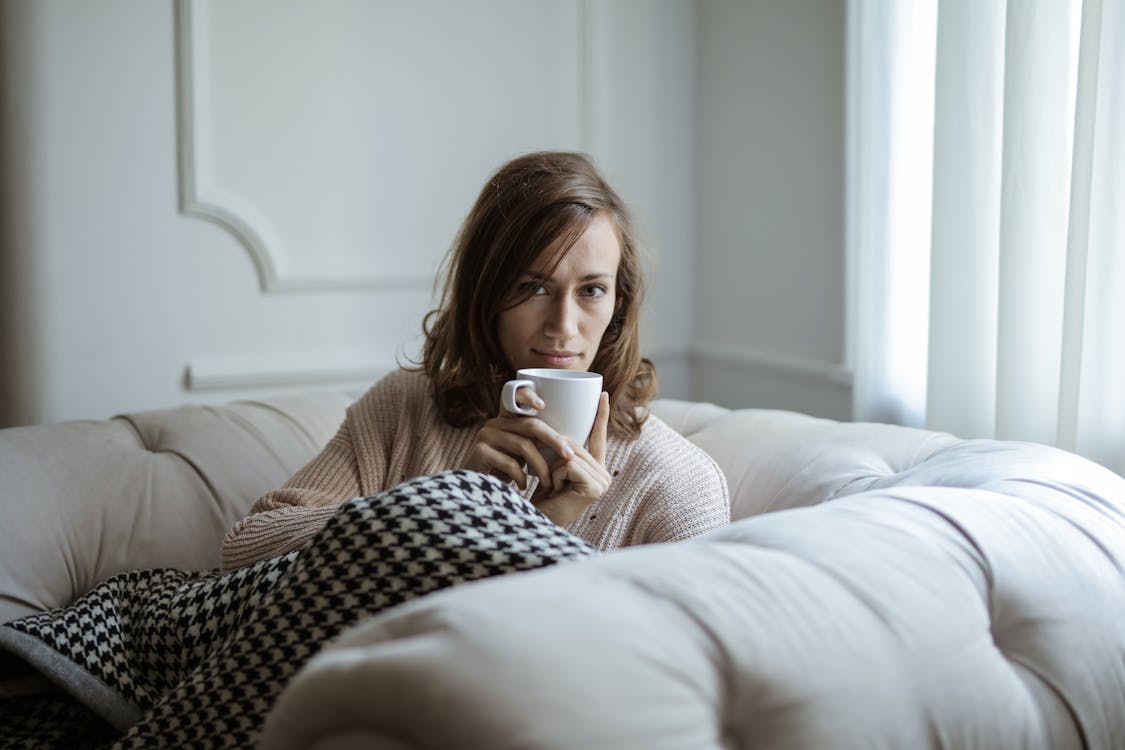 Photo of a Woman Drinking Coffee on White Ceramic Mug