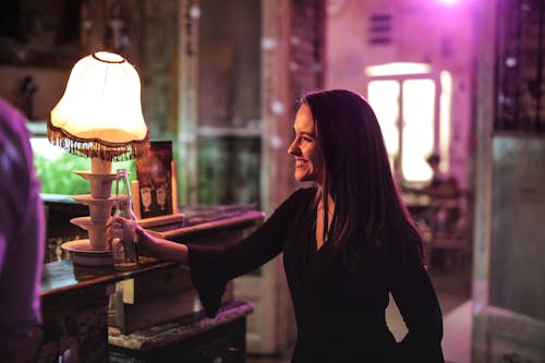 Woman in Black Long Sleeve Holding Beer Bottle