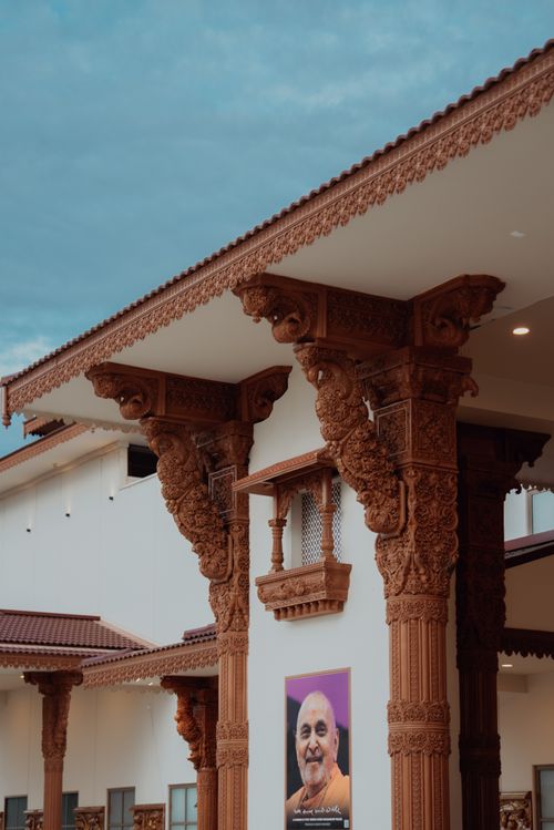 Free Detailed wooden carvings on architectural pillars of a cultural building, showcasing traditional design. Stock Photo