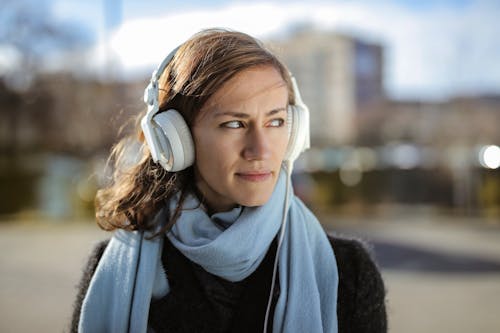 Woman in Black Sweater Listening To Music