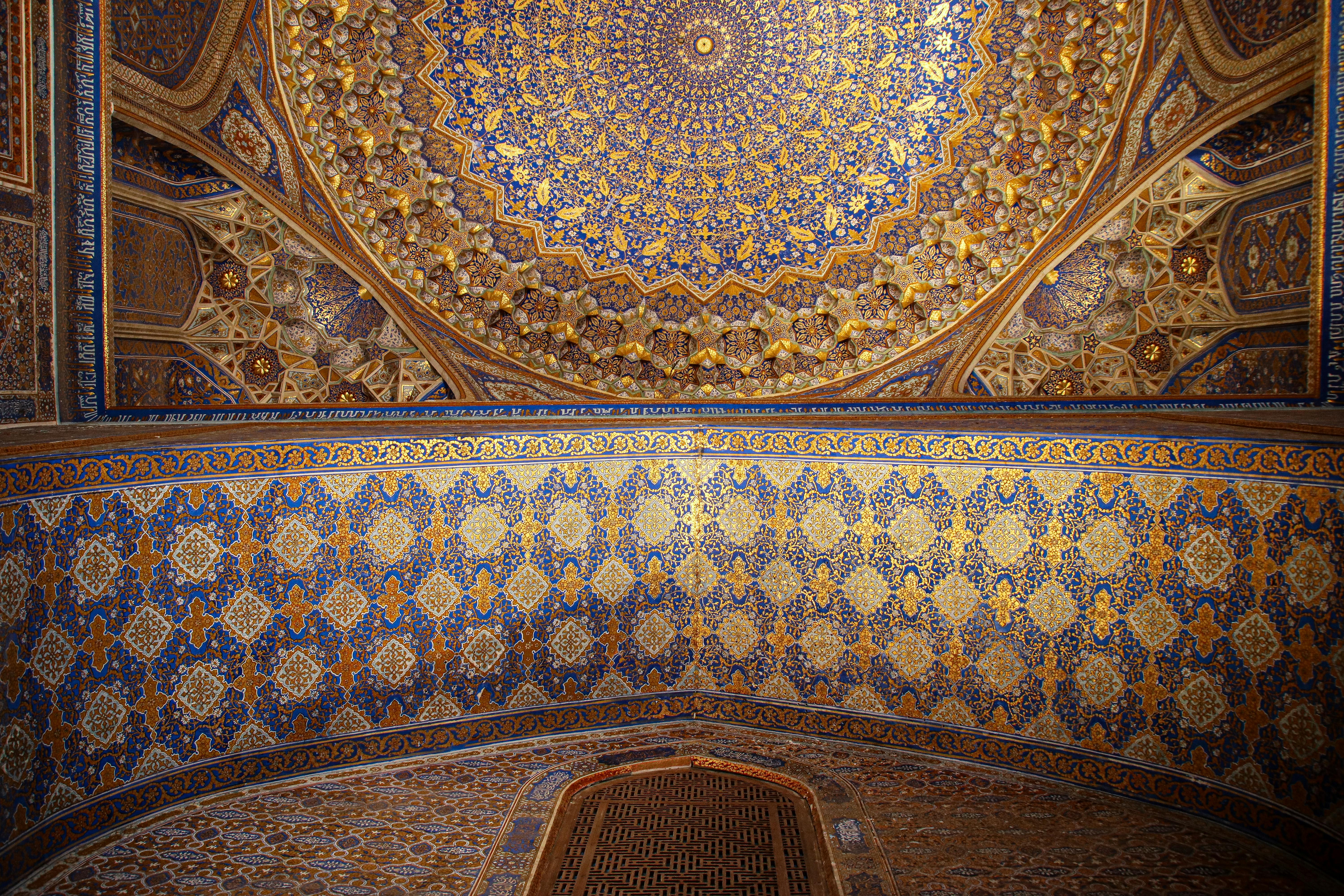 Ornately decorated ceiling of Tilya-Kori Madrasah in Samarqand, a masterpiece of Islamic architecture.