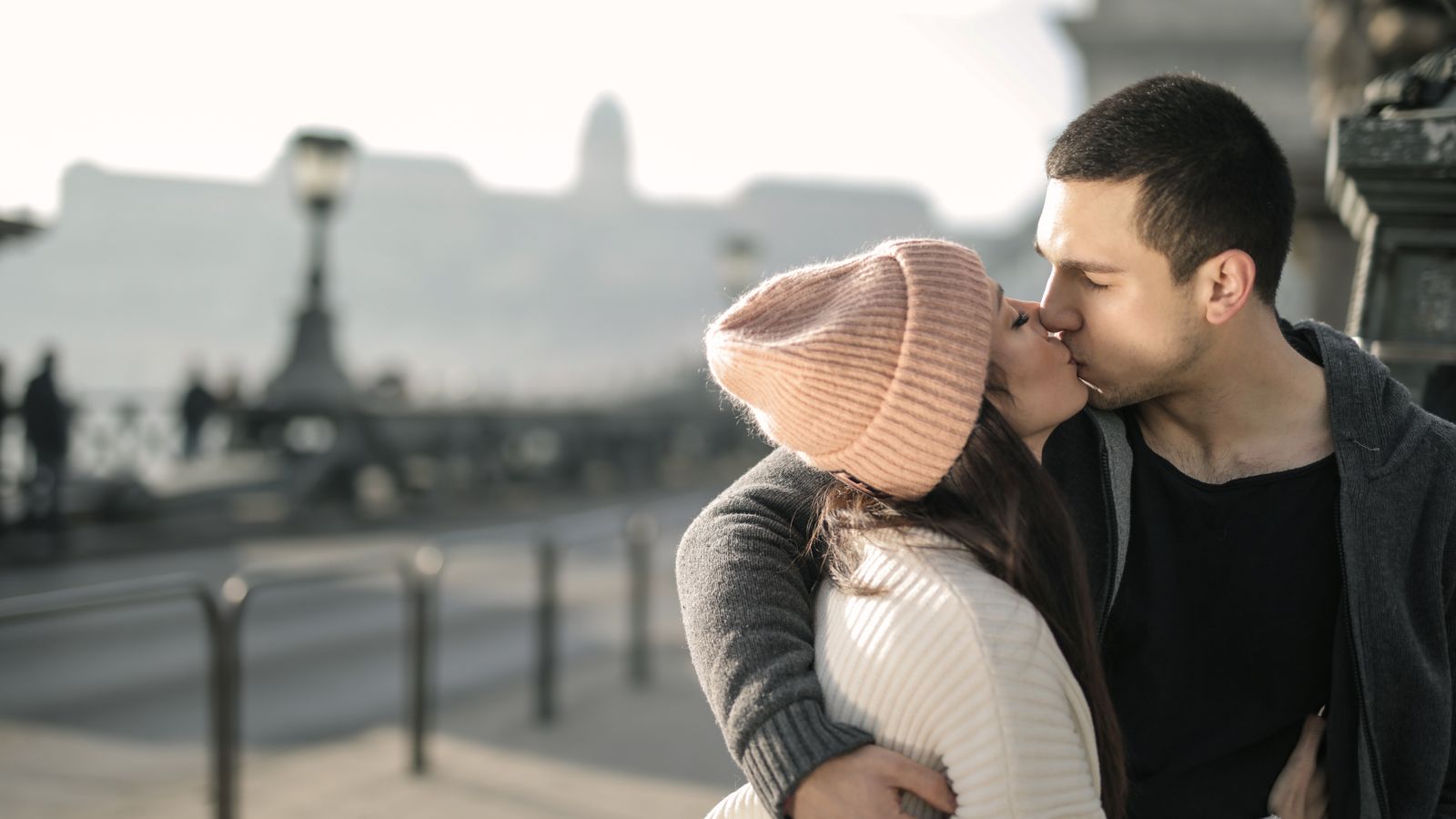 A couple hugging and kissing after reuniting outdoors in winter