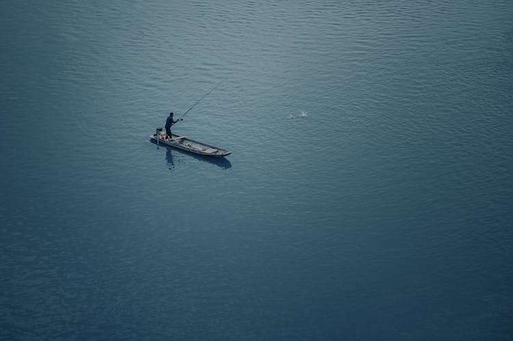 Man In Black Shirt Catching Fish