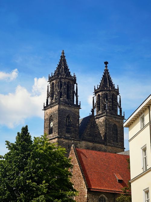 Free The majestic twin towers of Magdeburg Cathedral rise against a vibrant blue sky. Stock Photo