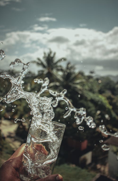 Всплеск воды на прозрачном стакане для питья