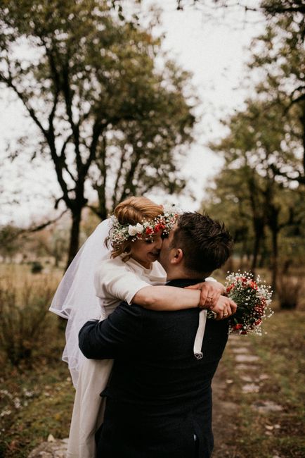 Bride and groom kissing outdoors in a romantic forest setting, capturing love and elegance.