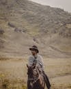 Man in Brown Cowboy Hat Riding A Horse