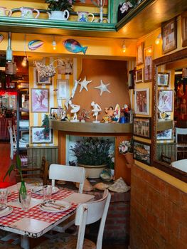 Charming Mediterranean-style restaurant with eclectic decor and checkered table setting.