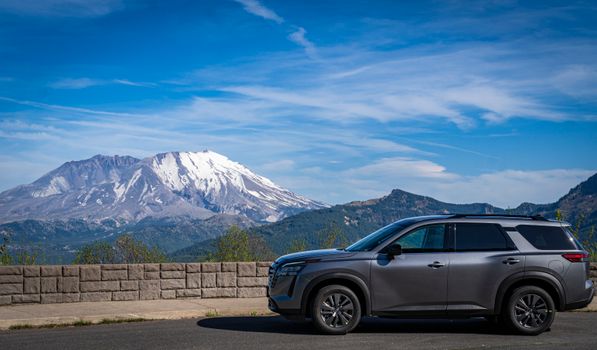 SUV parked with stunning view of Mount St. Helens on a clear sunny day in Washington.
