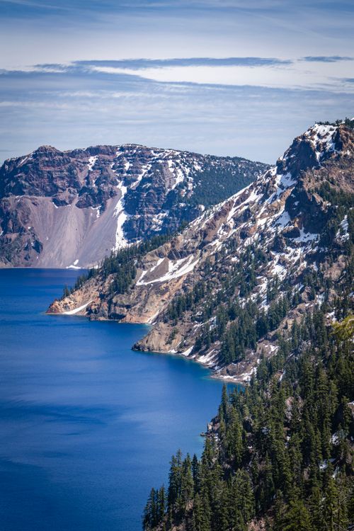 Free Breathtaking view of Crater Lake with snow-covered cliffs and deep blue water under a clear sky. Stock Photo