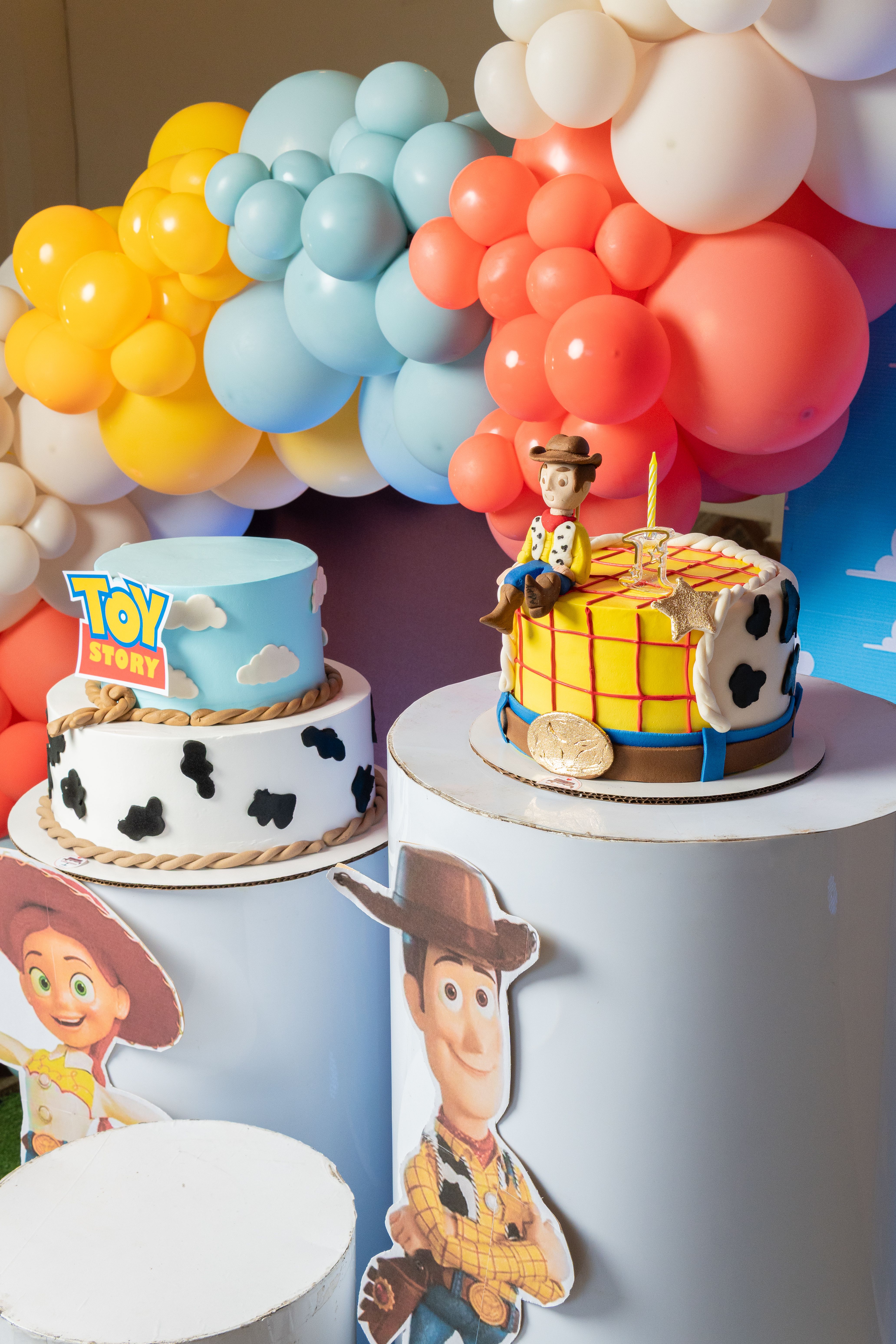 Vibrant Toy Story themed birthday party setup with cakes and balloons.