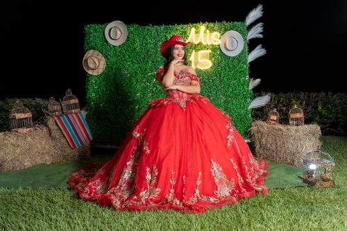 Free A young woman in a red gown celebrates her quinceañera proudly outdoors at night. Stock Photo