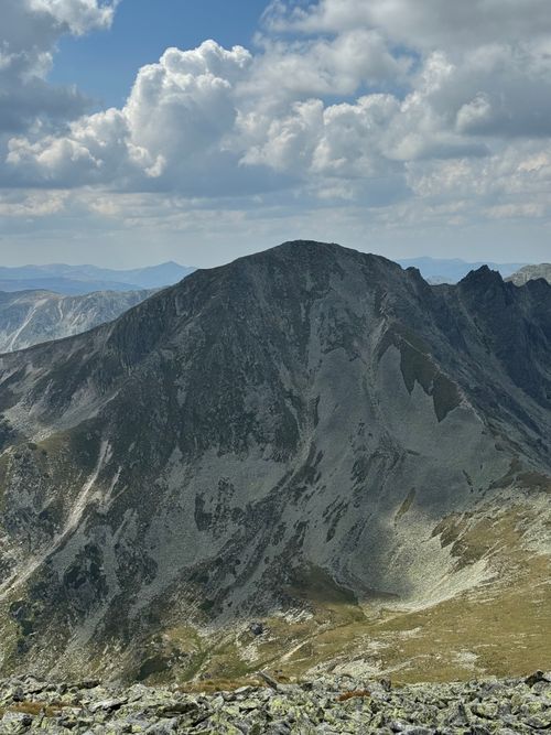 Free Majestic mountain peak with rocky terrain under a cloudy blue sky, ideal for nature and travel themes. Stock Photo