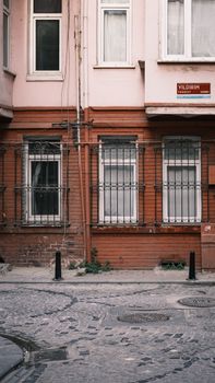 A picturesque view of an urban street featuring a rustic brick facade with vintage windows and cobblestone pavement.