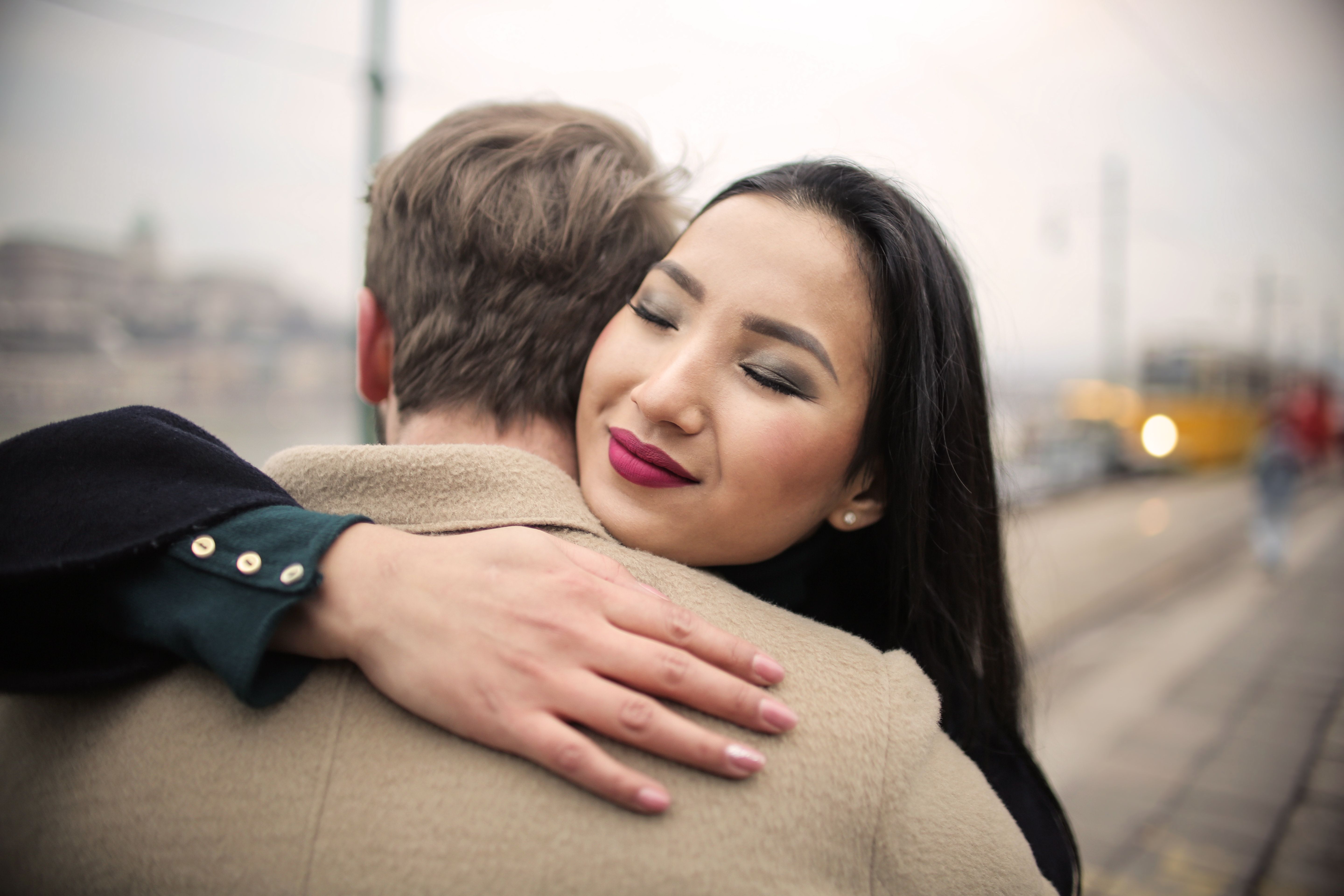 Woman in Black Coat Hugging Man in Brown Coat · Free Stock Photo