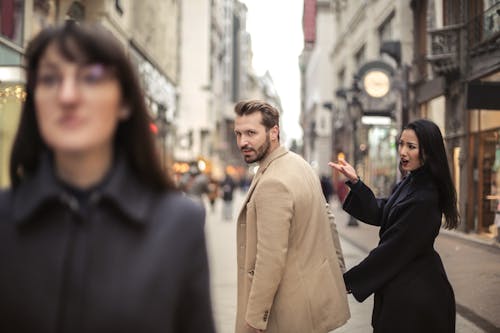 Man in Beige Coat Standing Near Woman in Black Coat