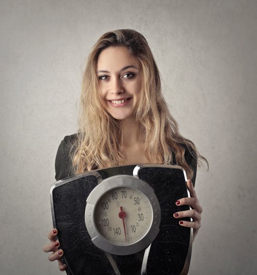 Woman in Black Shirt Holding Black and Silver Weight Scale