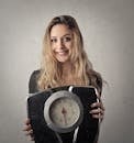 Woman in Black Shirt Holding Black and Silver Weight Scale