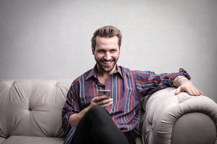 Man In Striped Long Sleeve Using Mobile Phones