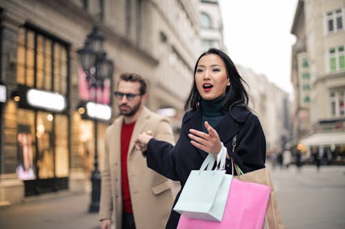 Woman in Black  Coat Holding Paper Bags