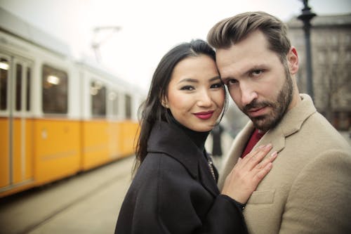 Man and Woman Standing beside Yellow Train
