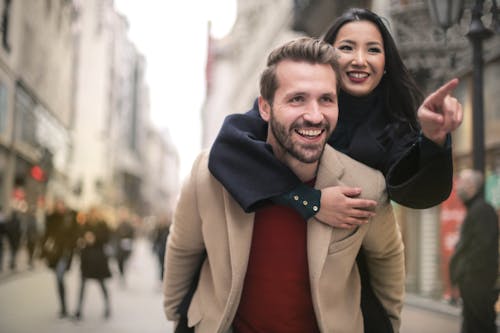 Pareja riendo mientras recorre la ciudad