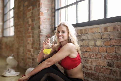 Free Woman in Red Brassiere Holding a Glass Bottle Stock Photo