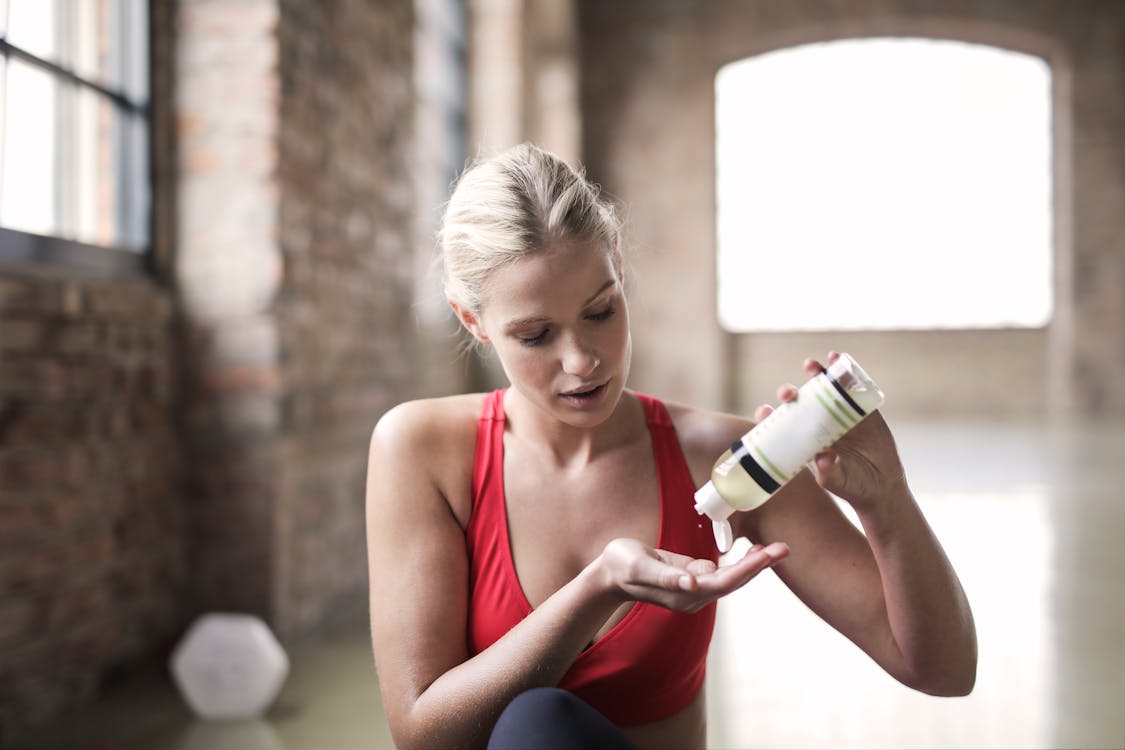 Free Woman in Red Sport Bra Putting a Lotion Stock Photo