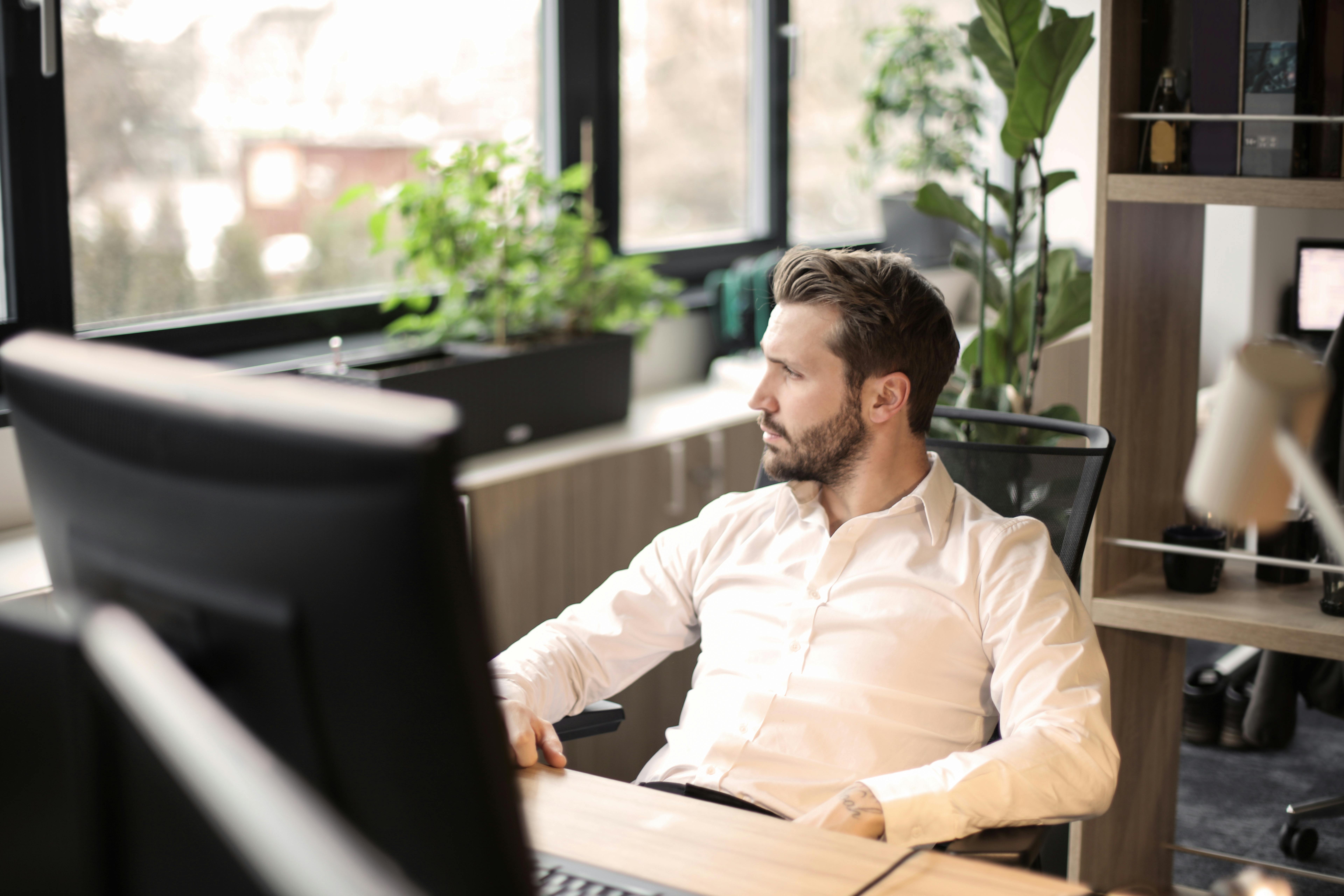 man in white shirt sitting on black chair