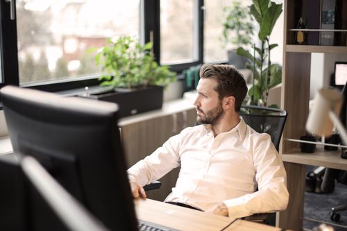 Free Man in white shirt working in a modern office with natural light. Stock Photo