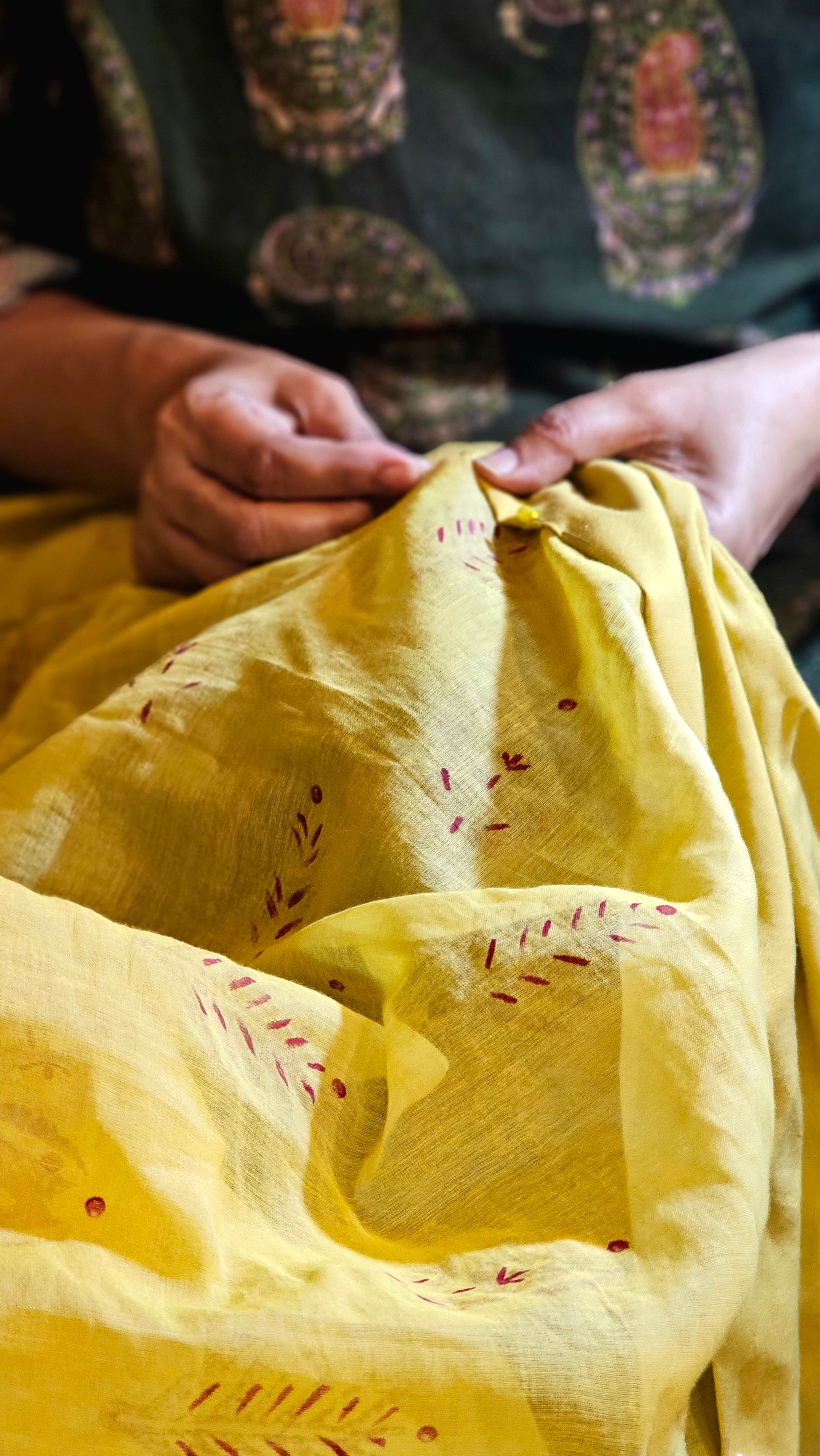 Indian artisan carefully hand-embroidering traditional textile