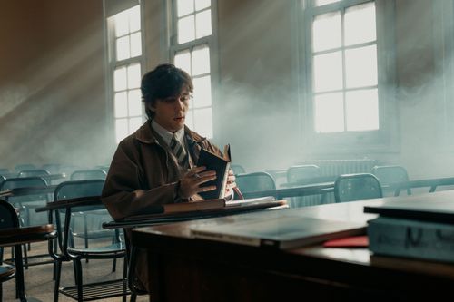 Free A young man immersed in reading inside an empty, sunny classroom in Buenos Aires. Stock Photo