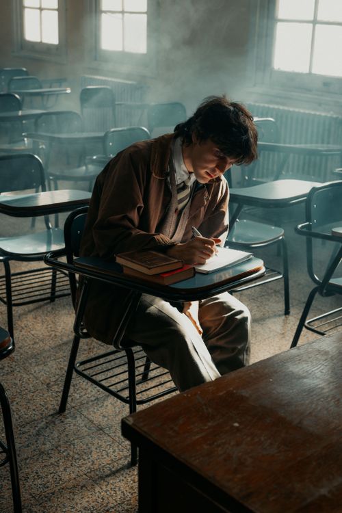 Free Young man engrossed in studies in a sunlit Buenos Aires classroom. Stock Photo