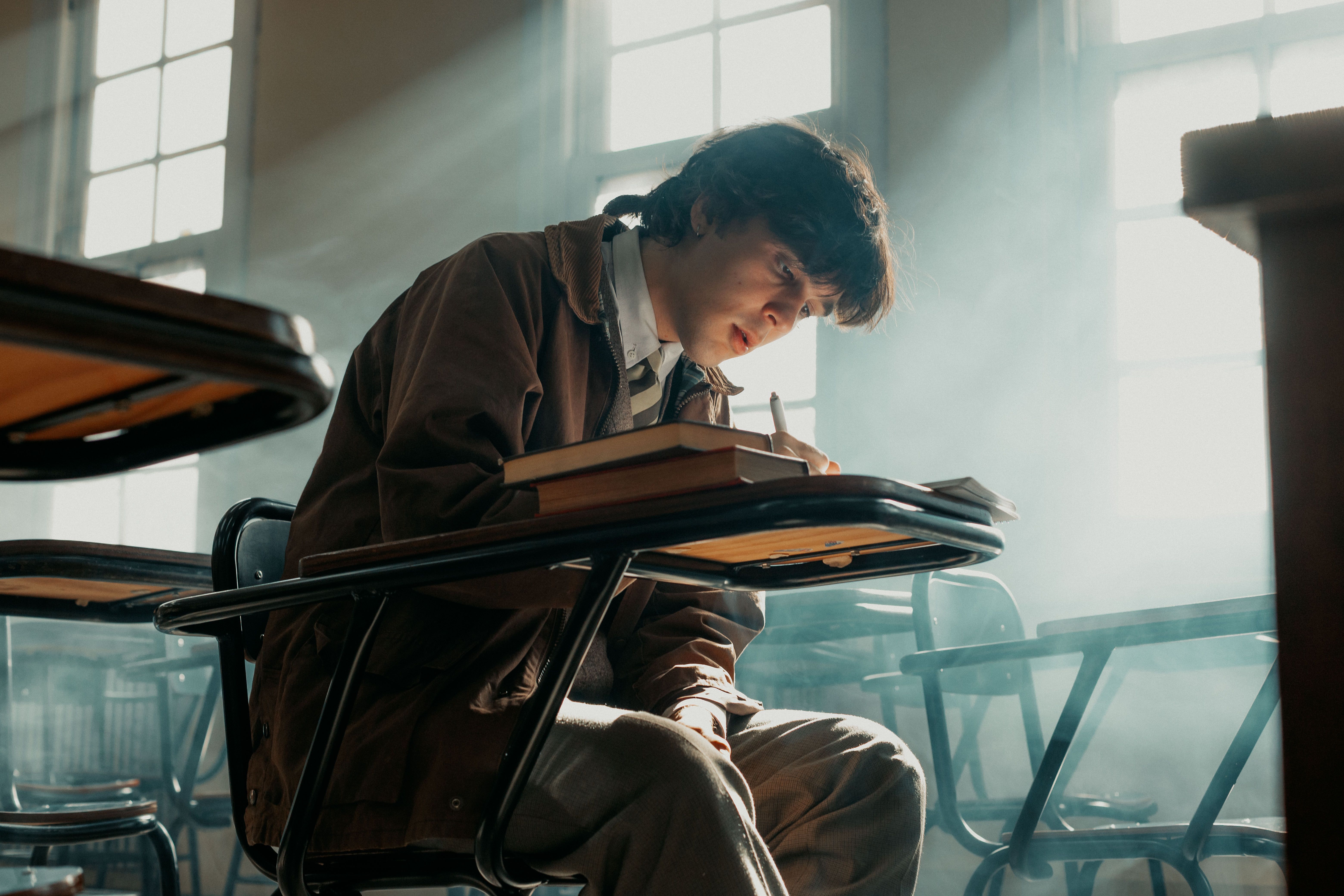 Focused Student Studying in Sunlit Classroom · Free Stock Photo