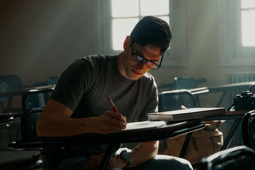 Young man studying in a sunlit university classroom in Buenos Aires, Argentina.