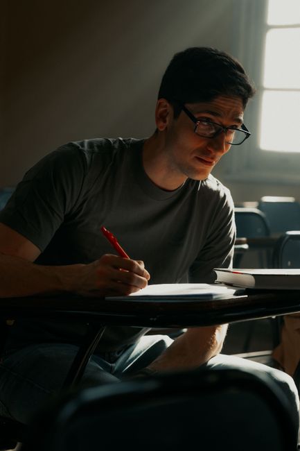 Young adult male concentrating on studies in a Buenos Aires classroom with sunlight streaming in. Young adult male concentrating on studies in a Buenos Aires classroom with sunlight streaming in.