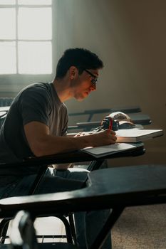 A focused university student studying in a sunlit classroom in Buenos Aires.