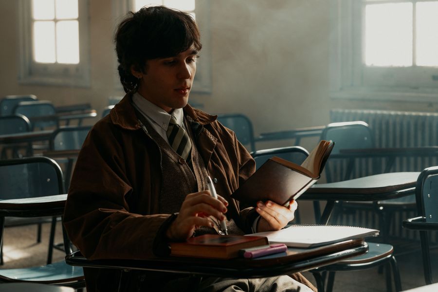 Adult male student reading in a Buenos Aires classroom during daytime.
