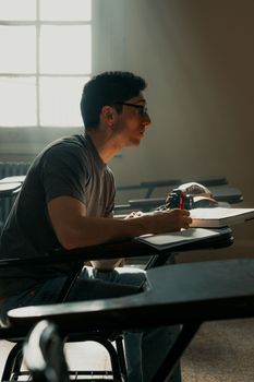 Male student focused at a desk in a classroom setting, Buenos Aires.