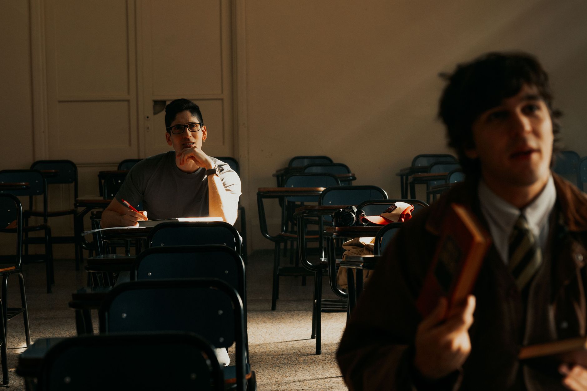 Two students in an Argentine university classroom studying during daylight.