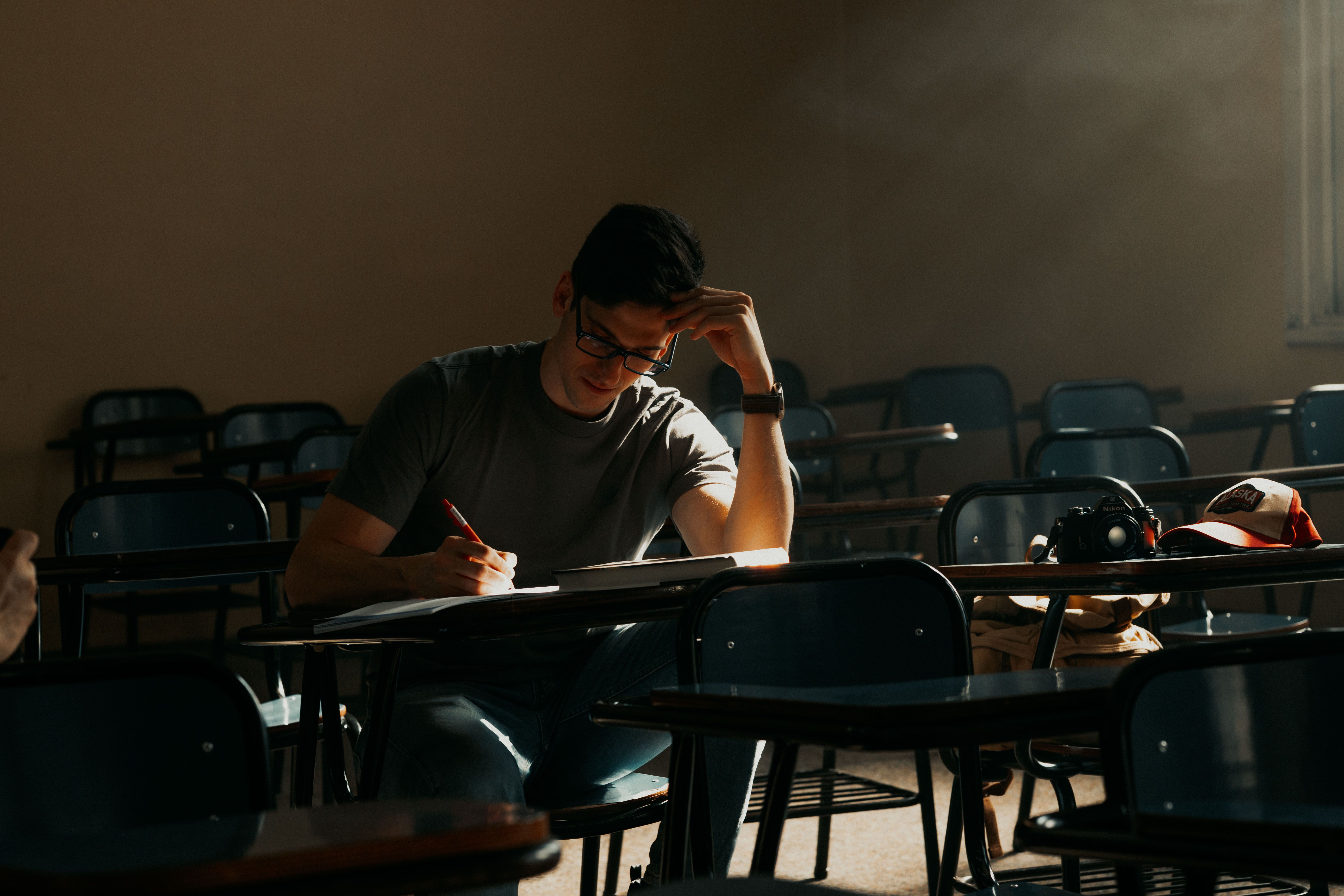 A male student intently studying in a sunny Buenos Aires classroom — modafinil for students exam prep