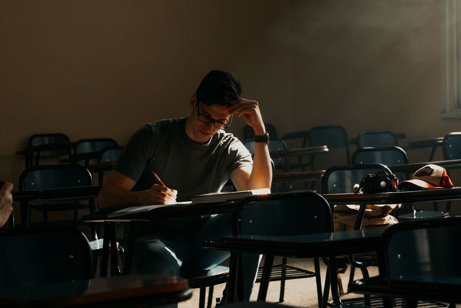 A male student intently studying in a sunny Buenos Aires classroom. A male student intently studying in a sunny Buenos Aires classroom.