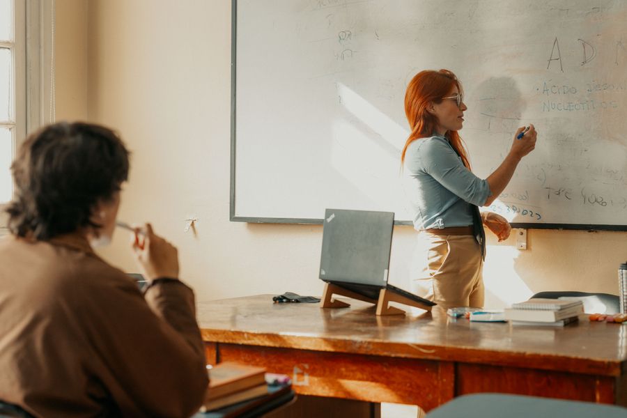 Instructor teaching a student in a Buenos Aires classroom with a whiteboard.