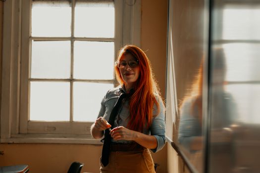 A young woman with red hair teaching in a sunny classroom in Buenos Aires, Argentina.