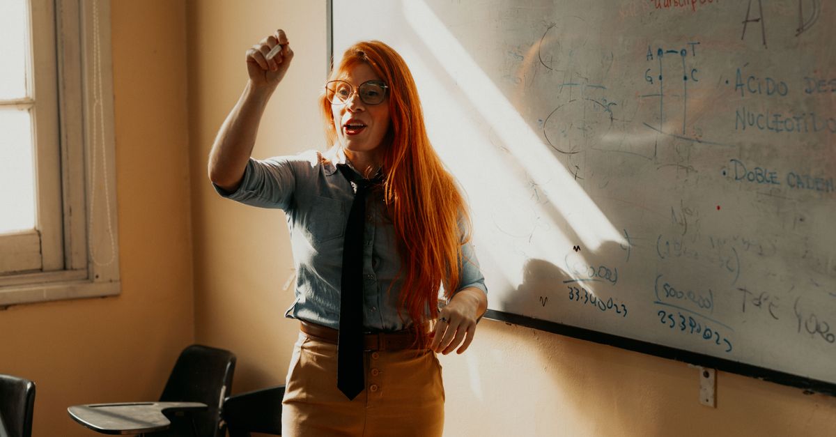 A teacher explaining a concept at a whiteboard. Bright classroom setting in Buenos Aires, Argentina.